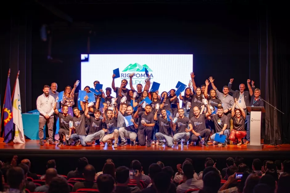 Alunos comemorando no palco durante cerimônia de formatura