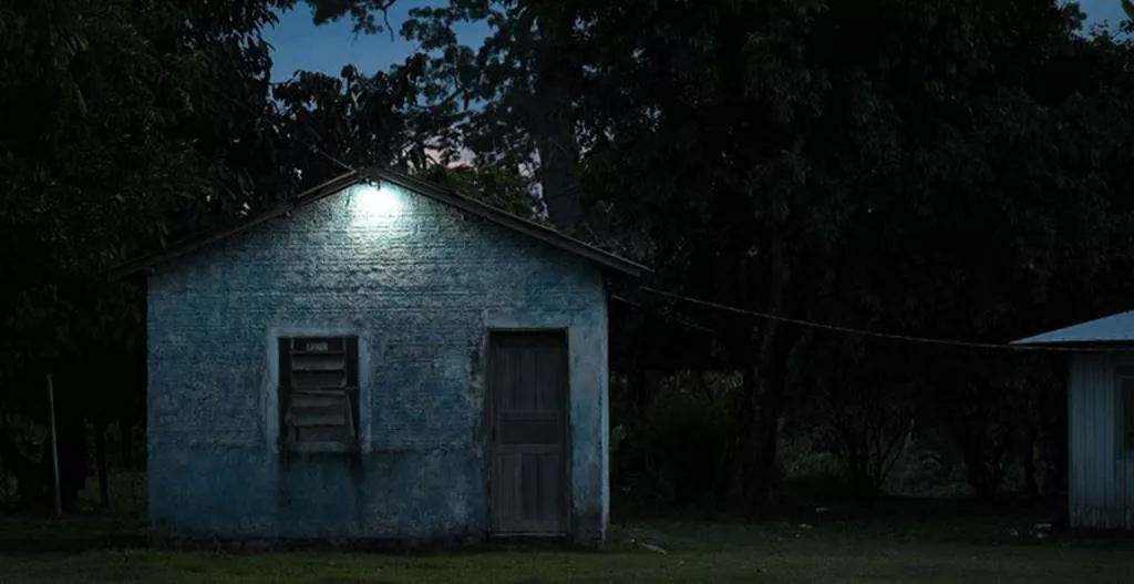 Casa no campo à noite iluminada por uma lâmpada