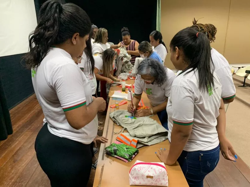 Mulheres pintam roupas na oficina de customização